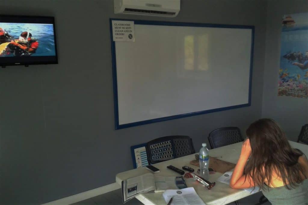 Marie lernt die Theorie für den Tauchkurs in Honduras