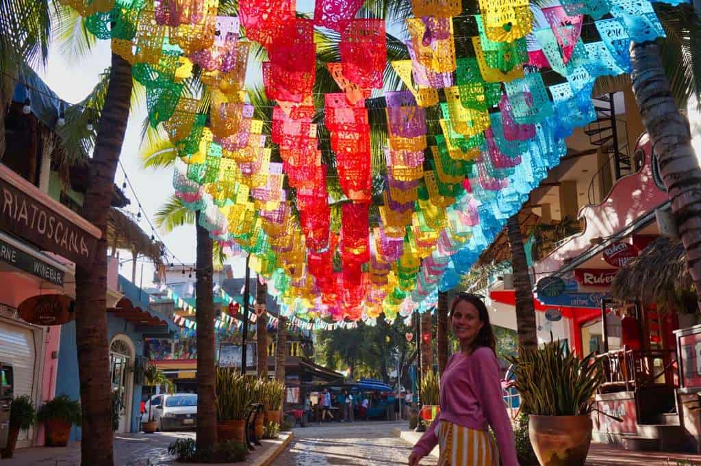 Marie posiert in einem bunten Fahnenmeer in Sayulita in Mexiko