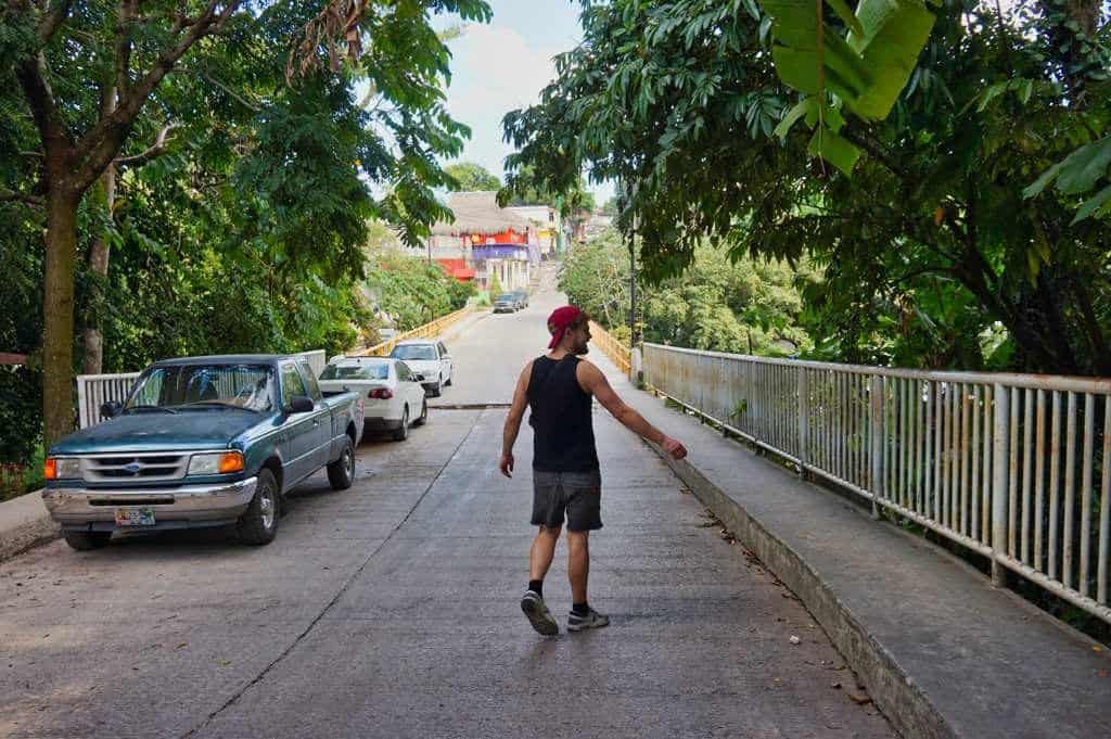 Chris läuft freudig über eine Brücke in der Stadt Palenque