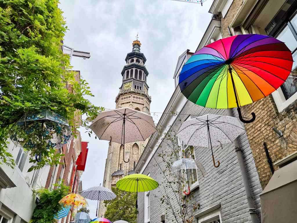 Blick auf den Langen Jan aus einer mit Regenschirmen überspannten Gasse