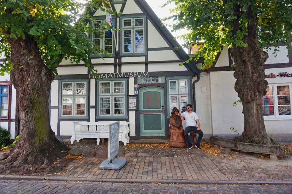 Chris sitzt vor dem Heimatmuseum in Warnemünde