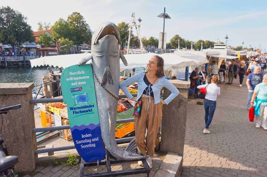 Marie posiert vor dem Fischmarkt in Warnemünde