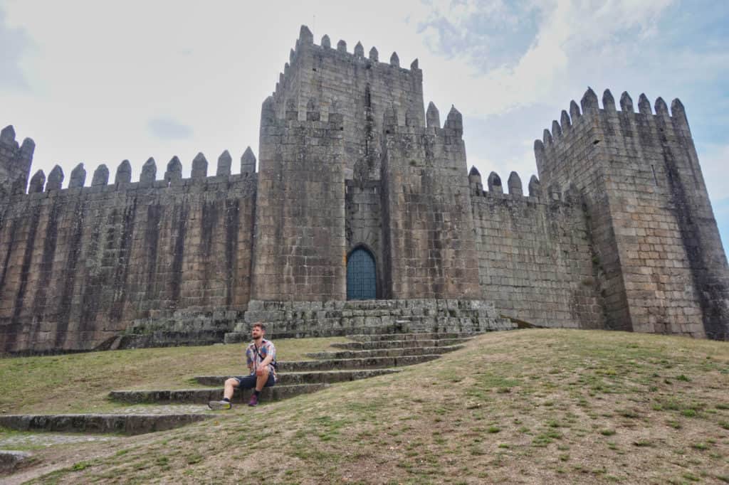 Chris sitzt vor dem Castelo in Guimaraes