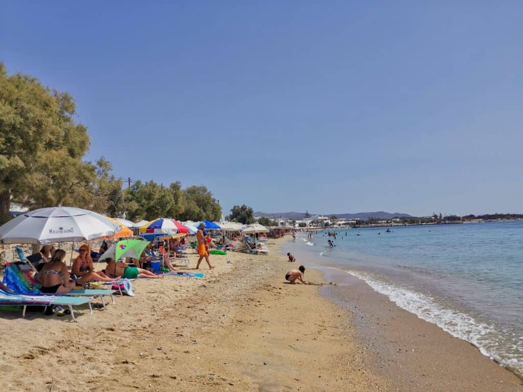 Der Strand von Agia Anna mit Sonnenschirmen und Menschen an einem sonnigen Tag