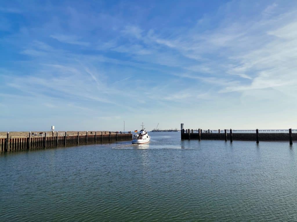 Ein Ausflugsschiff verlässt den Außenhafen von Hooksiel an der Nordsee.