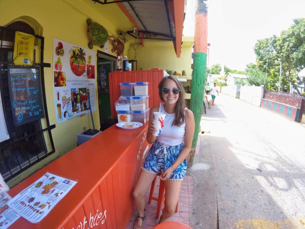 Marie trinkt einen Smoothie aus tropischen Früchten in Honduras an einem Straßenstand.