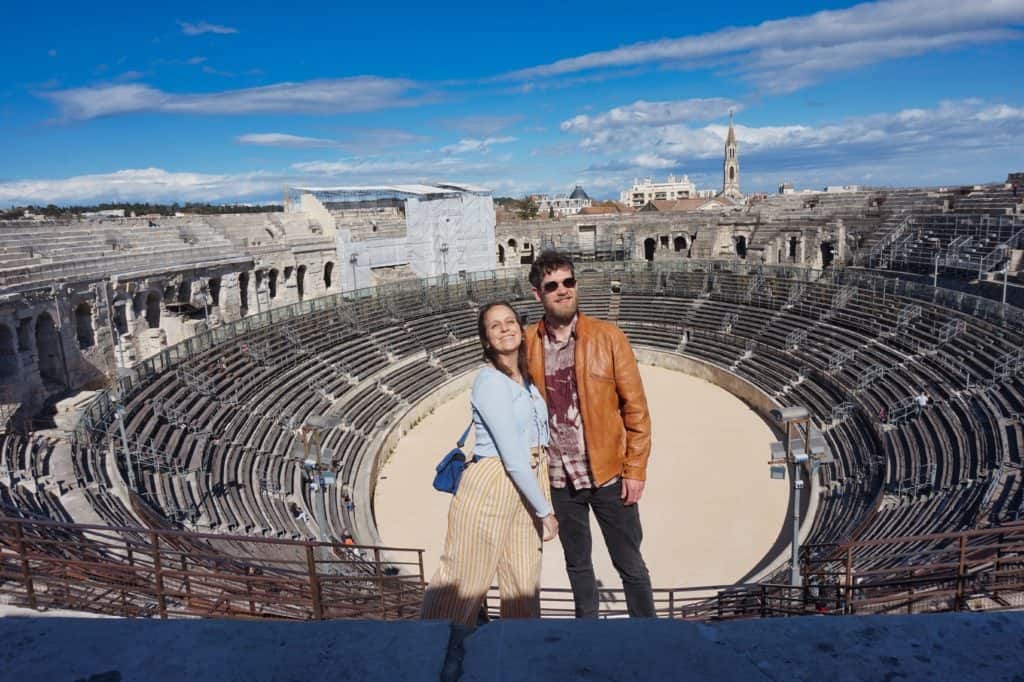 Marie und Chris stehen im Kolosseum von Nimes und berichten über ihre Reiseerfahrungen.