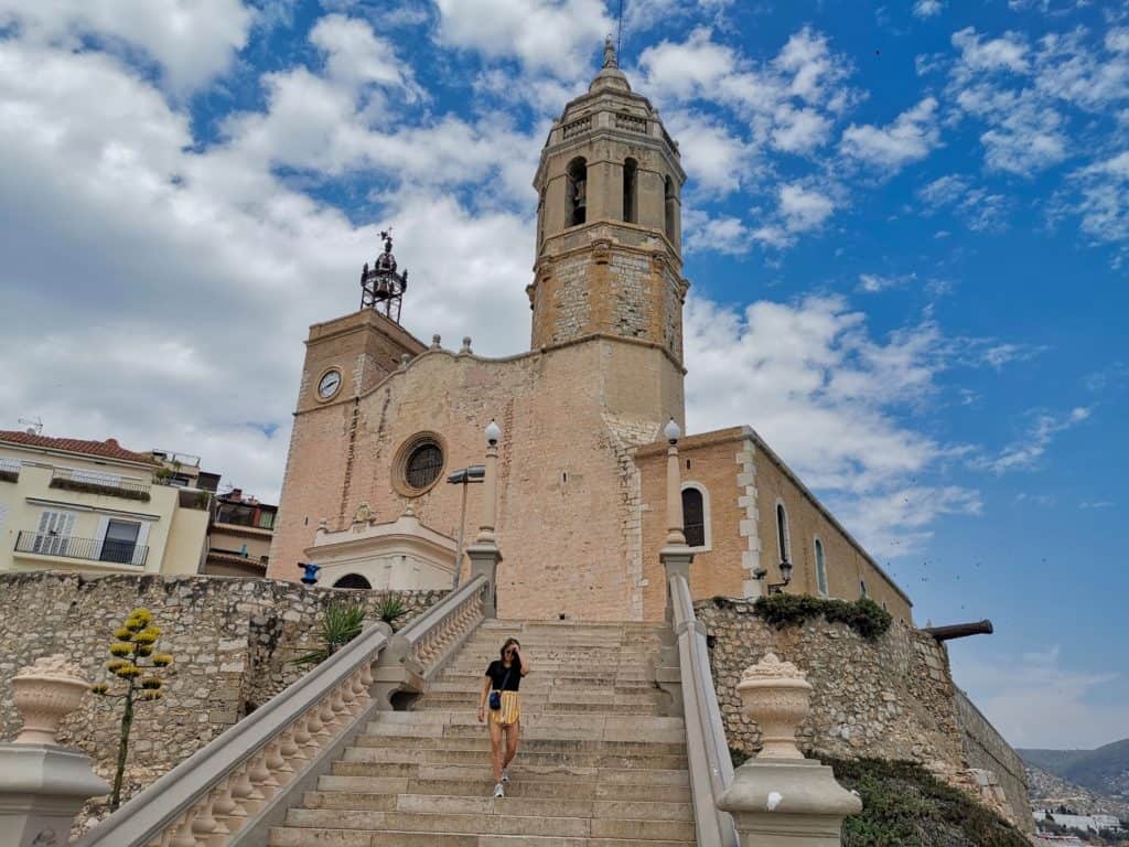 Marie geht die Stufen vor der Kathedrale von Sitges hinunter.