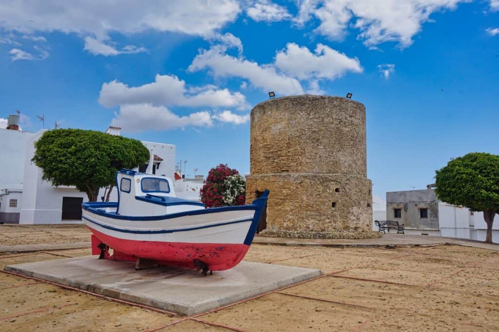 Boot und alte Mühle in der Altstadt von Conil de la Frontera in Spanien.