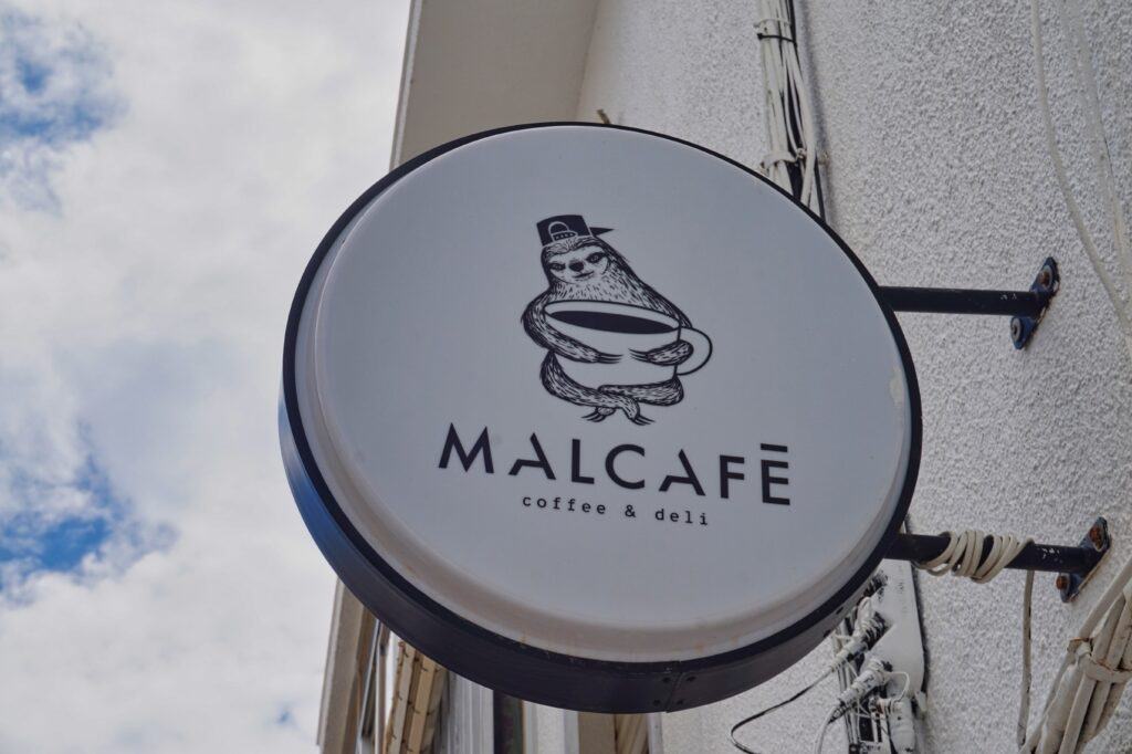 Schild des Cafés Malcafé im Zentrum von Conil de la Frontera.