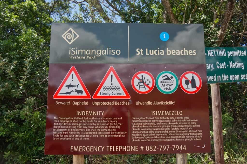 Ein Schild an einem Strand im iSimangaliso Wetland Park mit den möglichen Gefahren