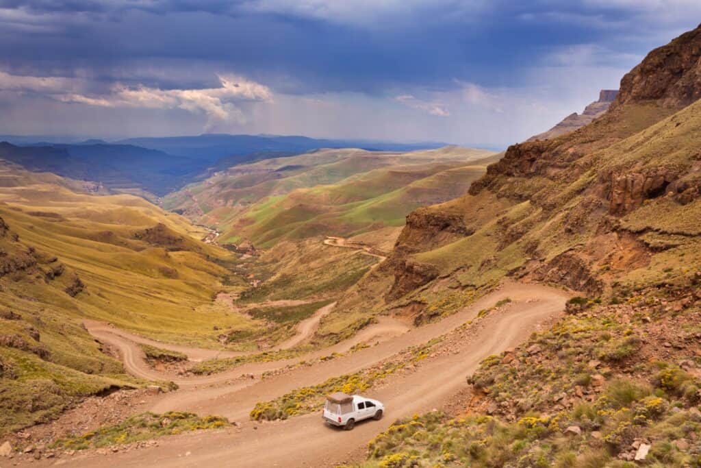 Ein Auto fährt die Serpentinen des Sani Pass entlang, dem Grenzübergang zwischen Südafrika und Lesotho in den Drakensbergen.