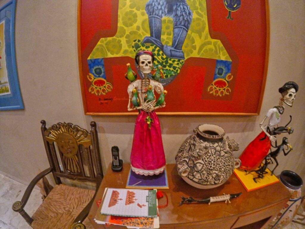 Zwei Catrina Puppen stehen vor einer bunten Wand in der Casa de los Venados in Valladolid