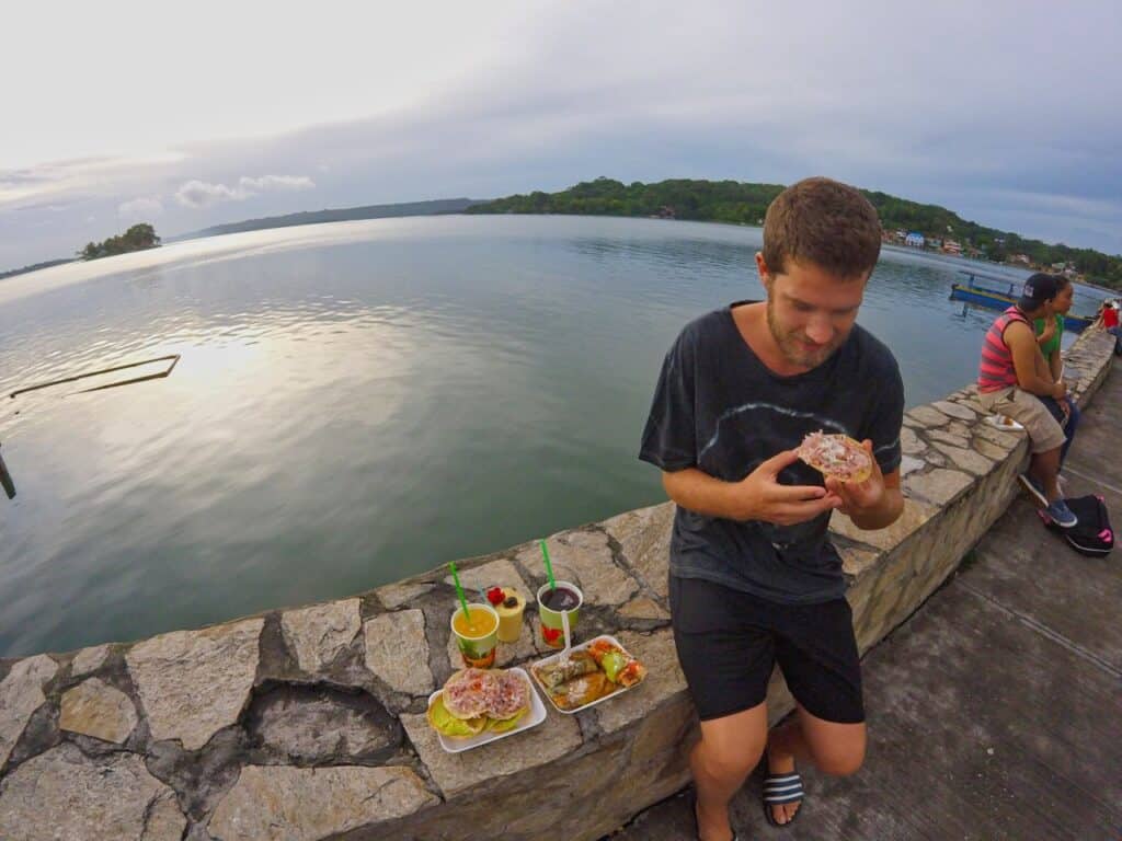 Chris isst leckere Tortas am Lago Petén Itzá.
