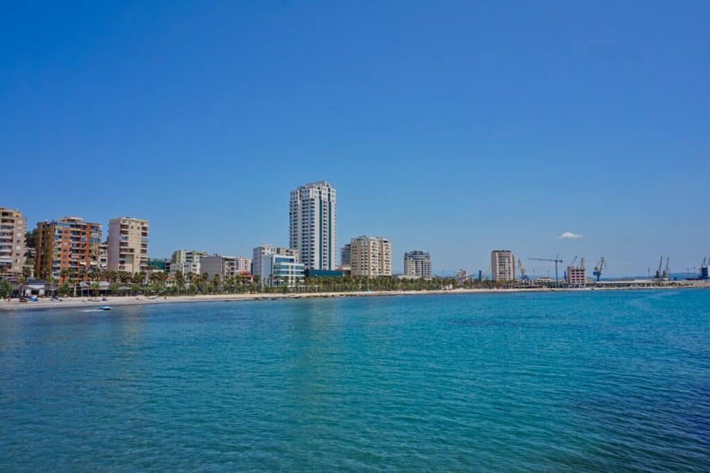 Die Strandpromenade in Durres mit Hochhäusern und Kränen