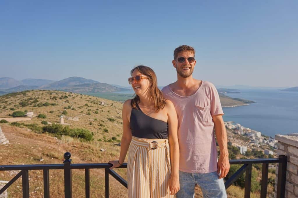 Marie und Chris stehen am Lekuresi Castle vor dem traumhaften Ausblick auf Saranda und das Meer