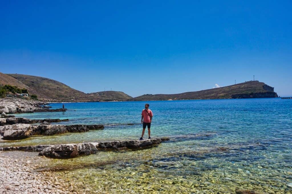 Chris steht am Strand von Porto Palermo im Süden von Albanien.