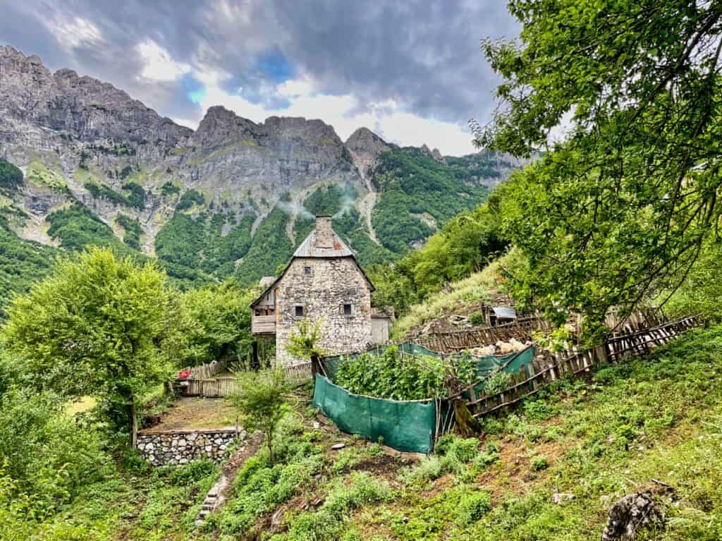 Haus und Bergpanorama auf der Wanderung von Valbona nach Theth in den albanischen Alpen.