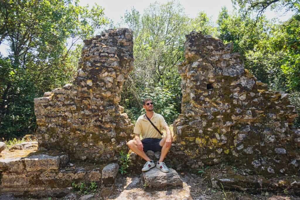 Chris sitzt auf Ruinen in Butrint Albanien