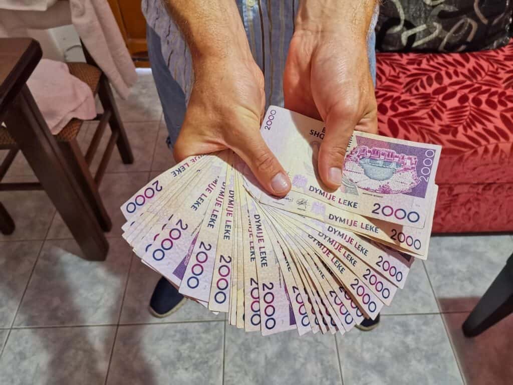 Chris hält die Albanien Währung lauter 2.000 Lek Scheine in seinen Händen