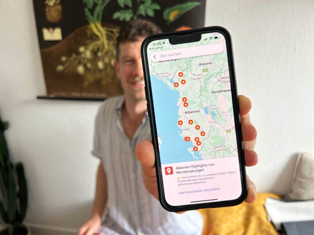 Chris hält das Handy mit unserer Albanien Highlights Karte