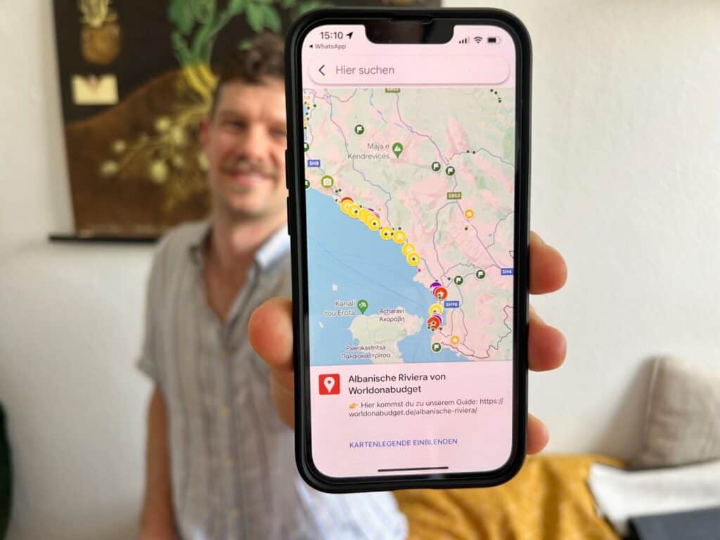 Chris hält das Handy mit unserer Albanische Riviera Karte