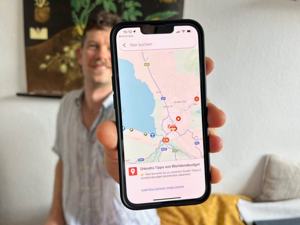 Chris hält das Handy mit unserer Shkodra Karte