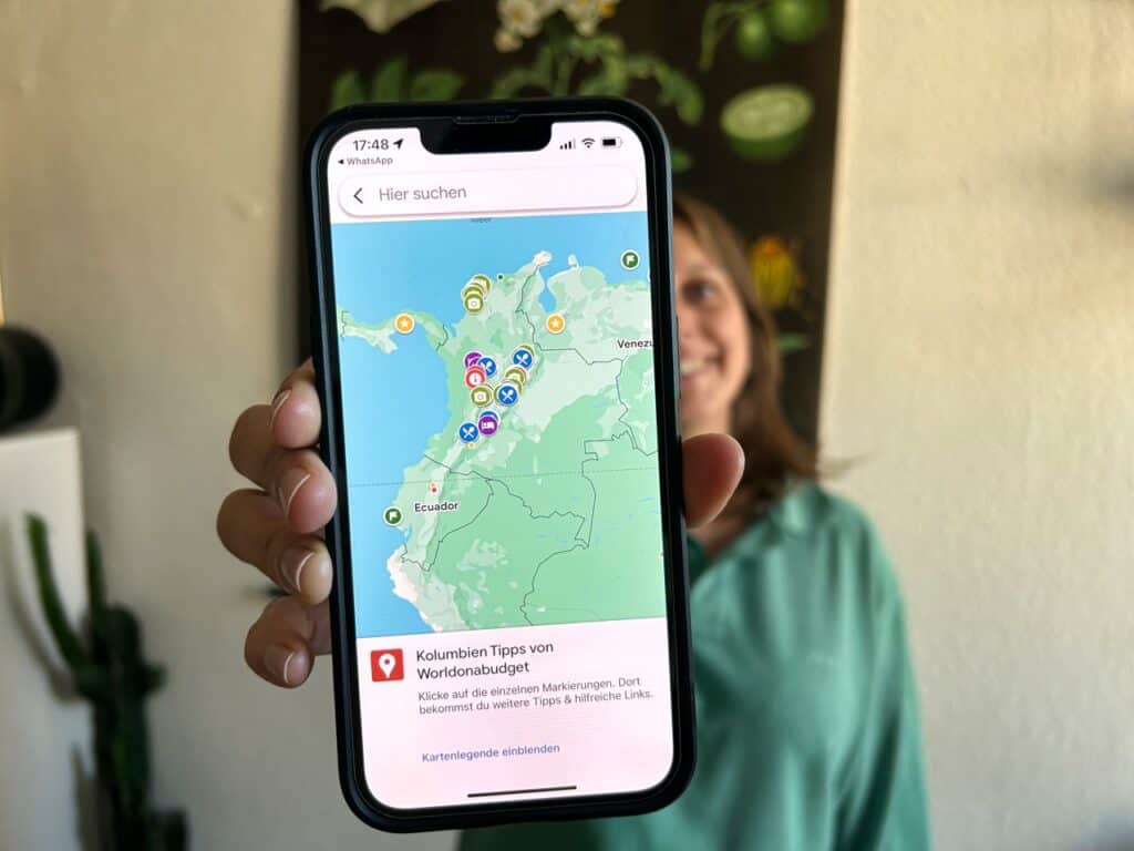Marie zeigt die Karte von Worldonabudget mit markierten Tipps in Kolumbien in die Kamera.