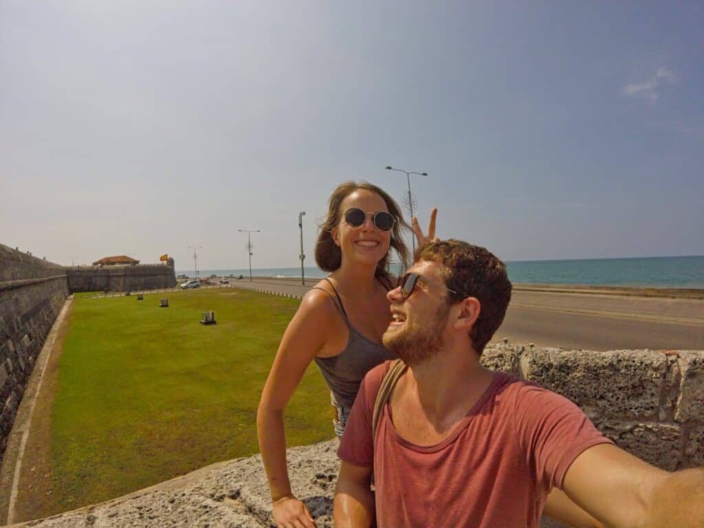 Marie und Chris sitzen in Cartagena auf der Stadtmauer und sprechen über die beste Kreditkarte für Kolumbien