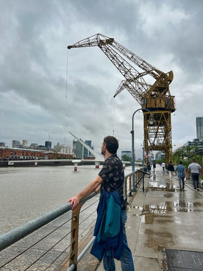 Chris am Hafenbecken mit einem Kran im Hintergrund in Puerto Madero, Argentinien.