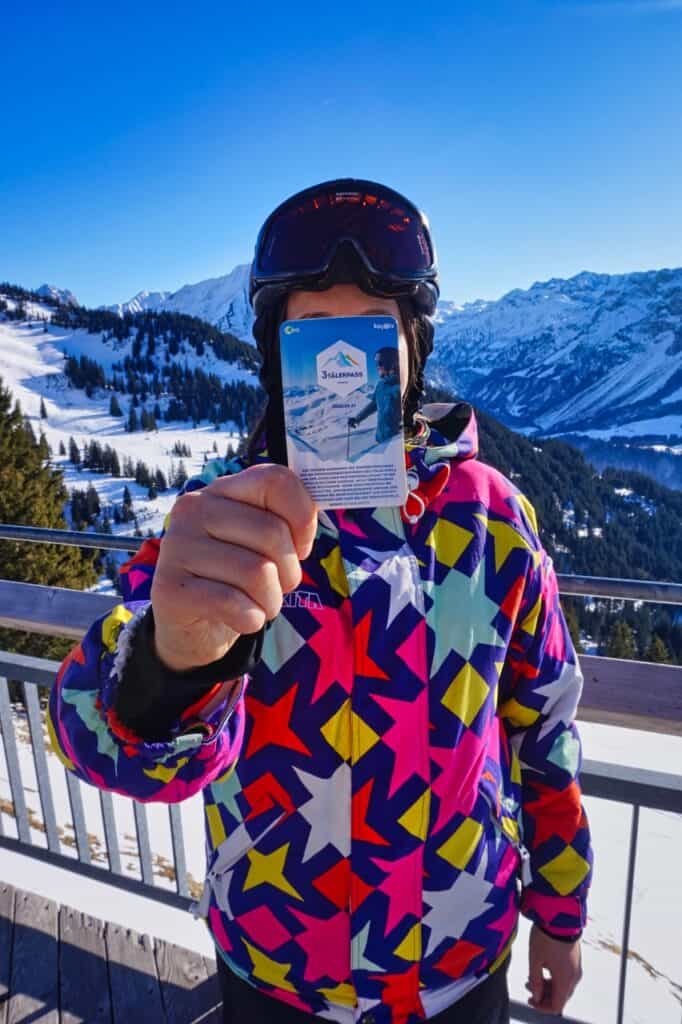 Marie zeigt den 3TälerPass, der in allen Skigebieten im Bregenzerwald gilt.