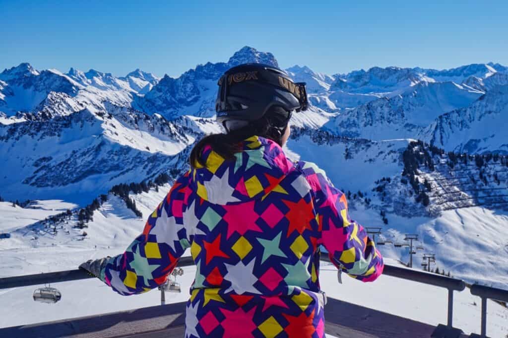 Marie bestaunt das Panorama am Diedamskopf im Bregenzerwald ein Österreich.