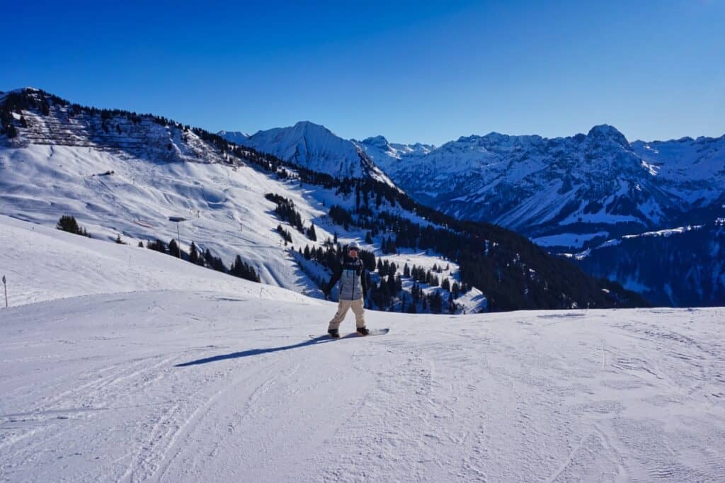 Chris vom Reiseblog Worldonabudget beim Snowboard fahren am Diedamskopf, unserem Geheimtipp für ein Skigebiet.