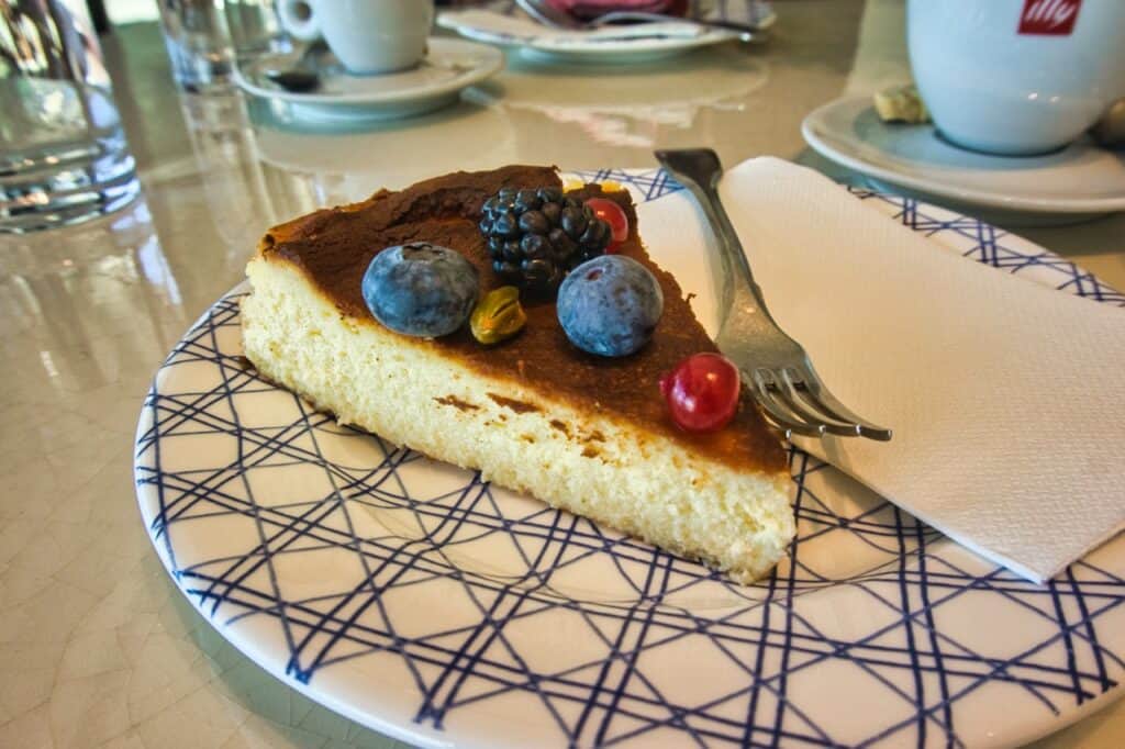 Ein Stück Cheesecake mit Blaubeeren, Johannisbeeren und einer Brombeere als Topping bei Katarina's Patisserie Rovinj