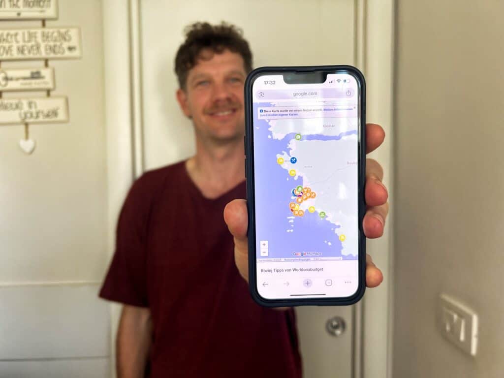 Chris hält sein Handy in der Hand, auf dem unsere Karte von Rovinj zu sehen ist
