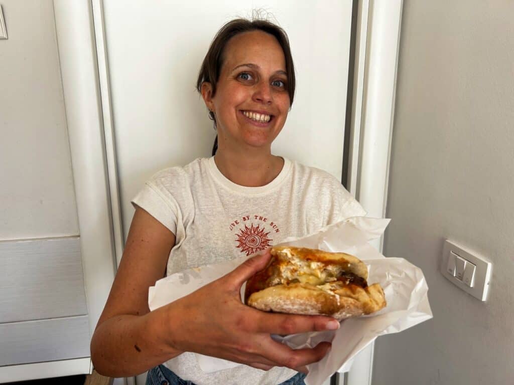 Marie hält ein Cevapcici Sandwich der Kantun Paulina in die Kamera