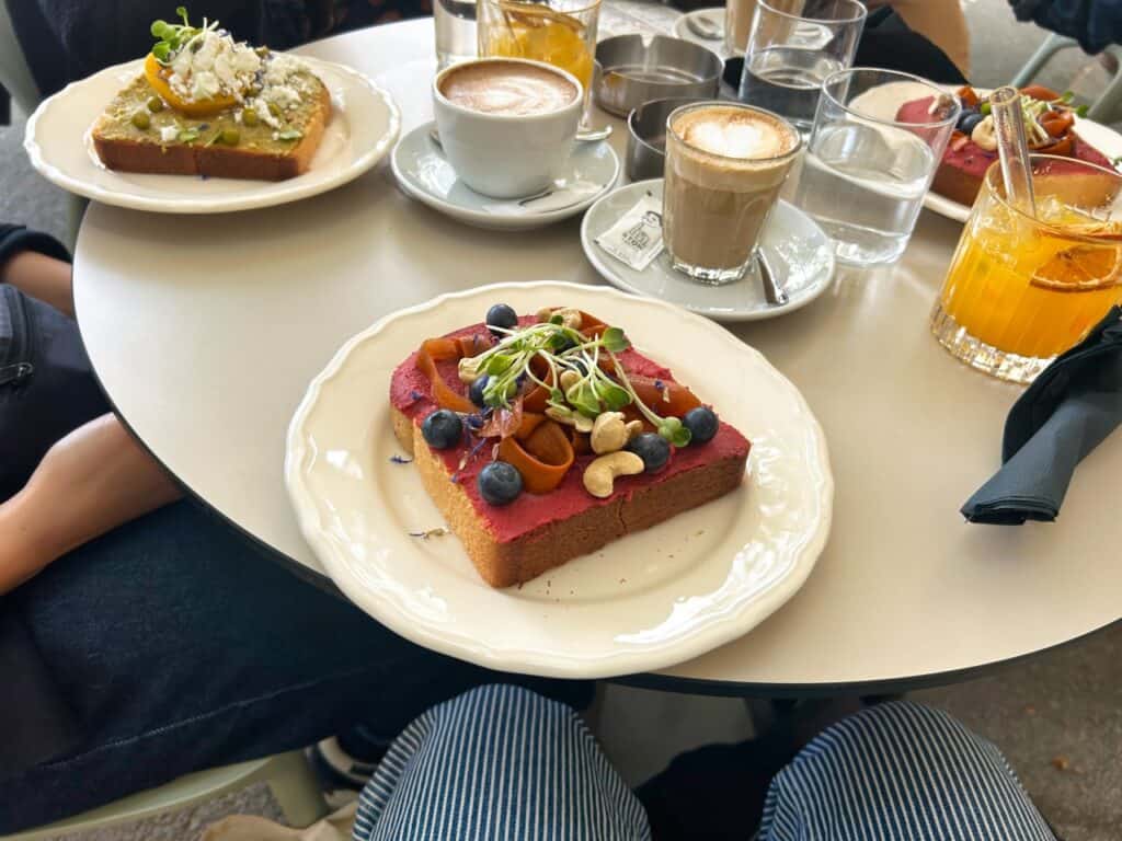 Frühstückskombi mit einem fancy belegten Brot mit Rote Beete Humus, Blaubeeren, Cashew und veganem Lachs bei Stow Coffee Roasters