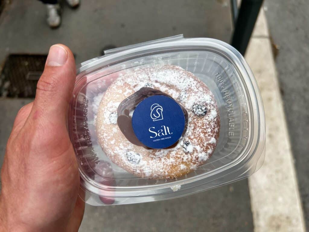 Chris hält seinen glutenfreien Donut vom SALT Restaurant in Split in der Hand