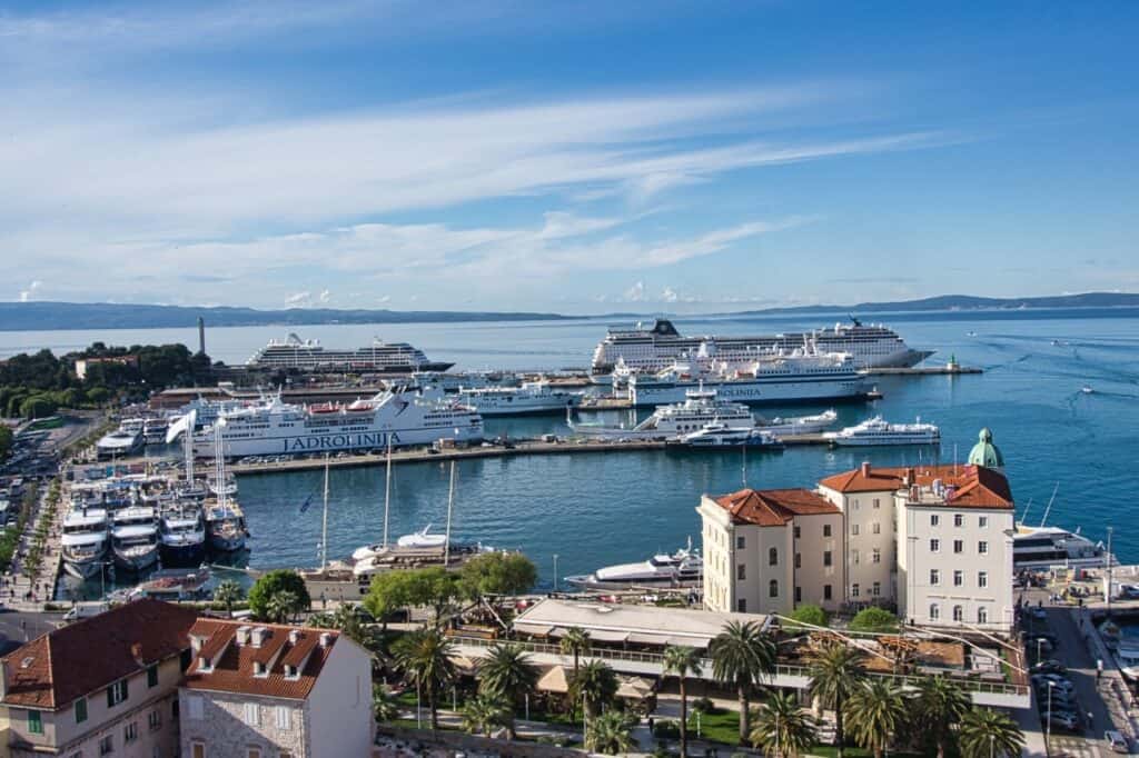 Blick auf den Hafen von Split mit einem großen Kreuzfahrtschiff und einigen Fähren