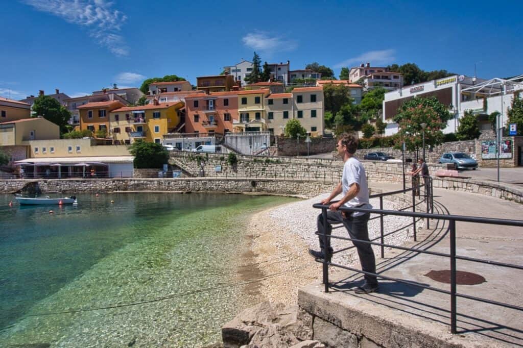 Chris ist an der Strandpromenade in Rabac und blickt aufs Meer.