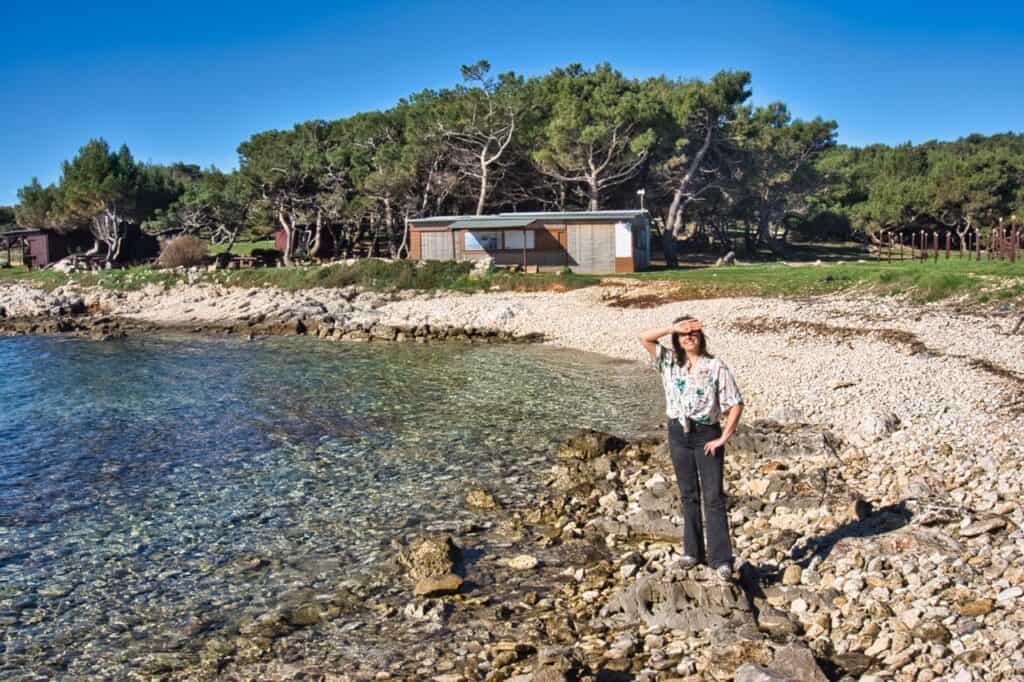 Marie vom Worldonabudget Reiseblog steht an einem Strand am Kap Kamenjak bei Medulin.
