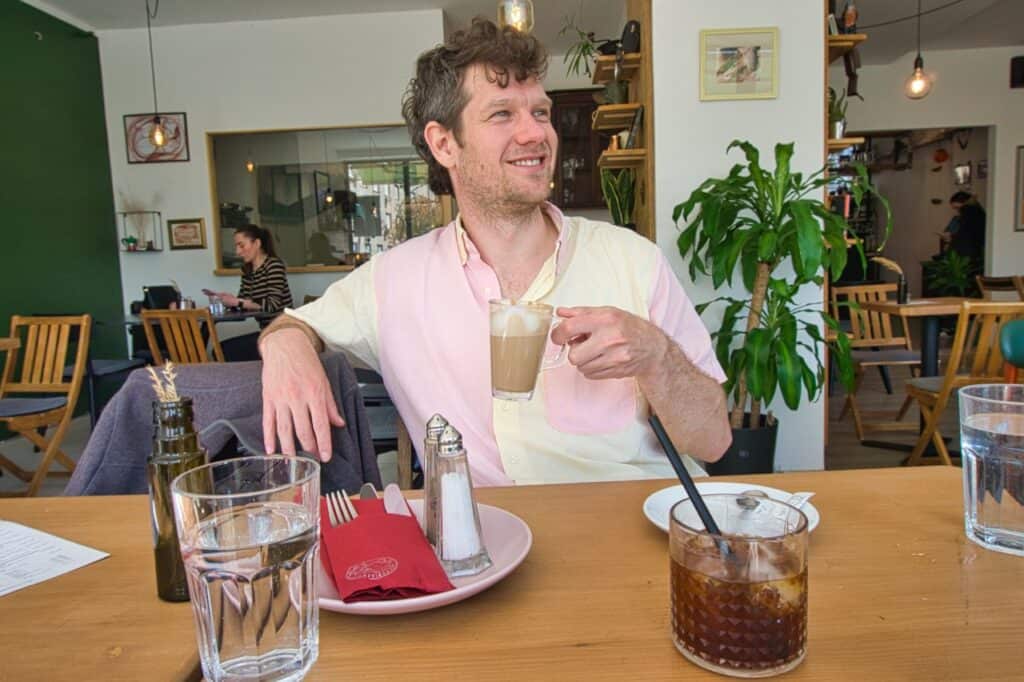 Chris sitzt im Cafe und denkt über die Kosten für Urlaub in Kroatien nach