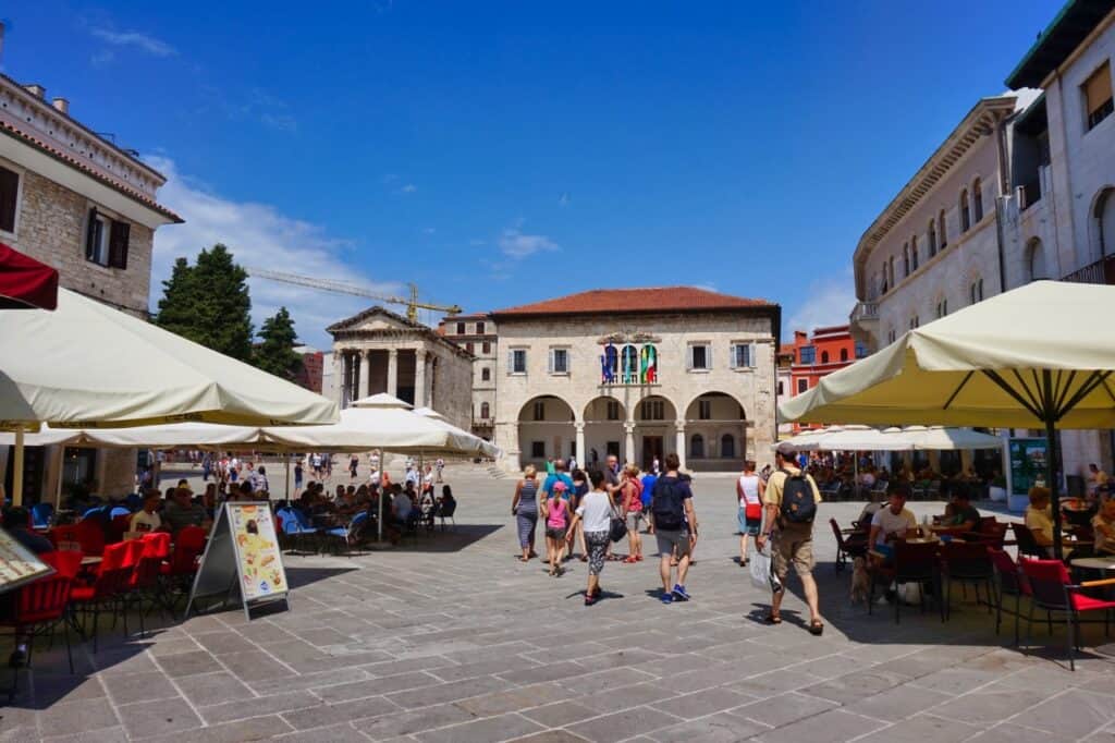 Viele Menschen und Cafés auf dem Forum von Pula