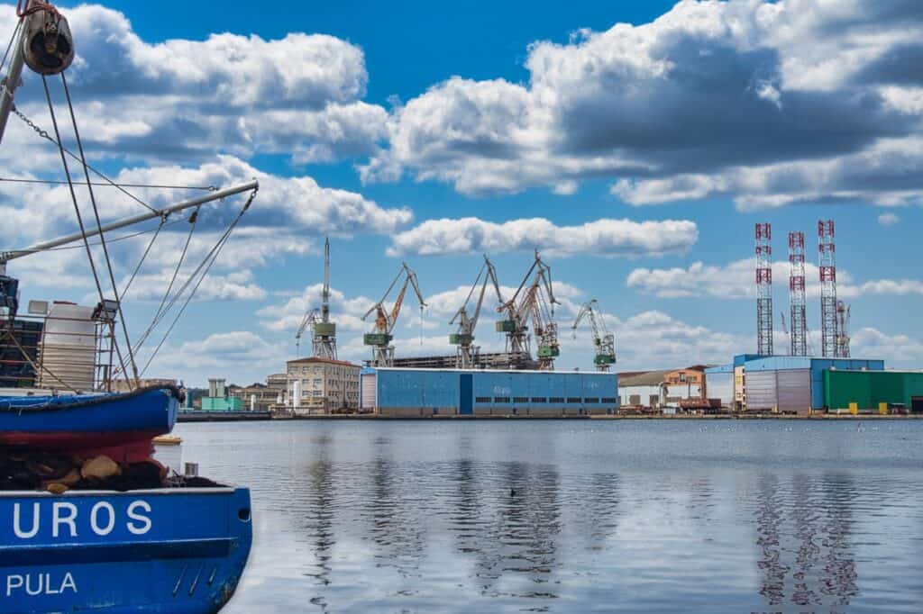 Blick auf die Schiffswerft, während auf der linken Seite die Hälfte von einem Schiff zu erkennen ist, ist für ein toller Geheimtipp in Pula