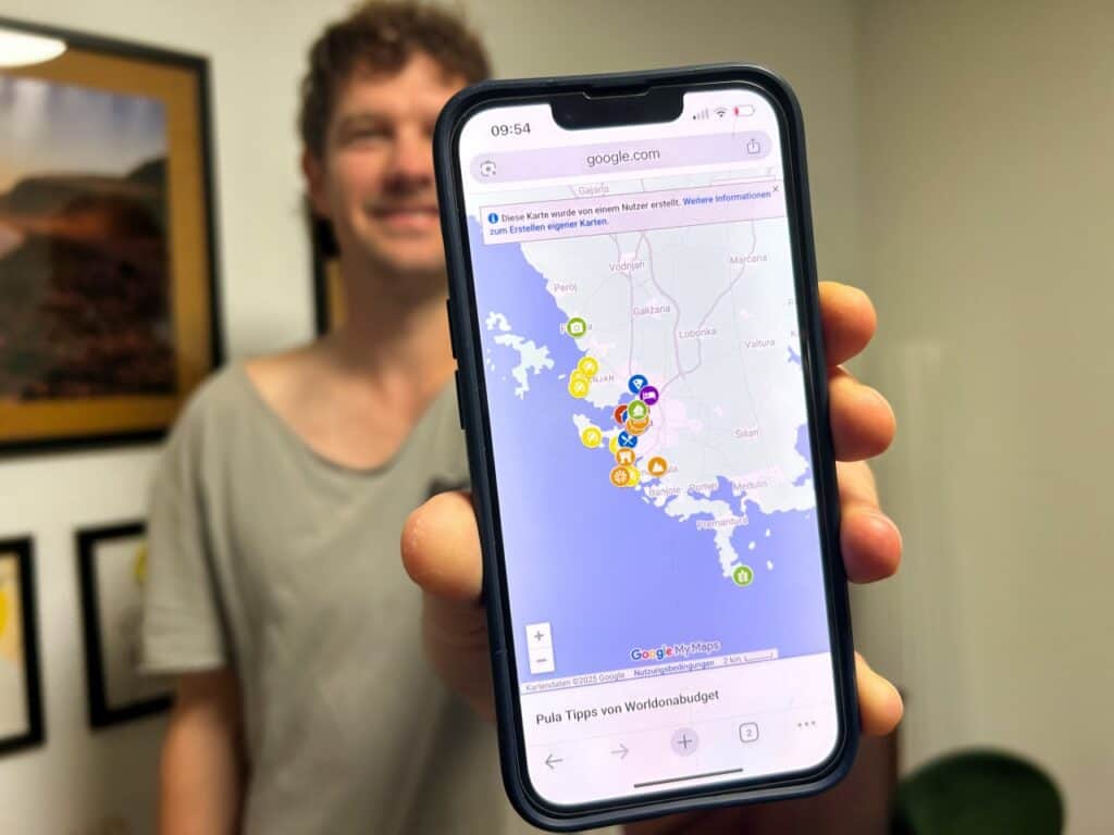 Chris hält sein Handy in der Handy, auf dem eine Karte von Pula zu sehen ist