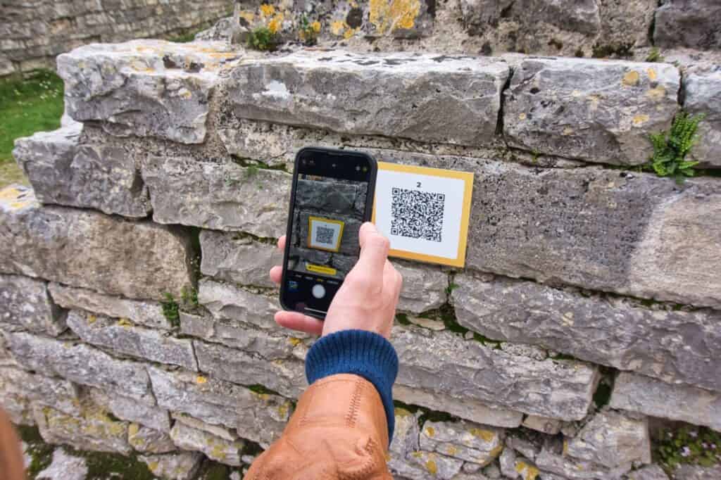 Chris scannt mit seinem Handy einen QR Code in der Arena in Pula
