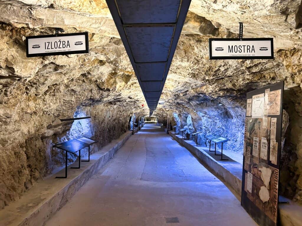 Blick in den langen Tunnel der Zerostrasse in Pula mit Tafeln der Ausstellung über die Straßenbahn